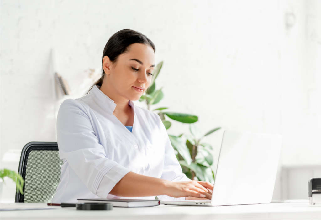 Dermatologist using laptop to access SKNV prescription platform for immediate patient medication ordering