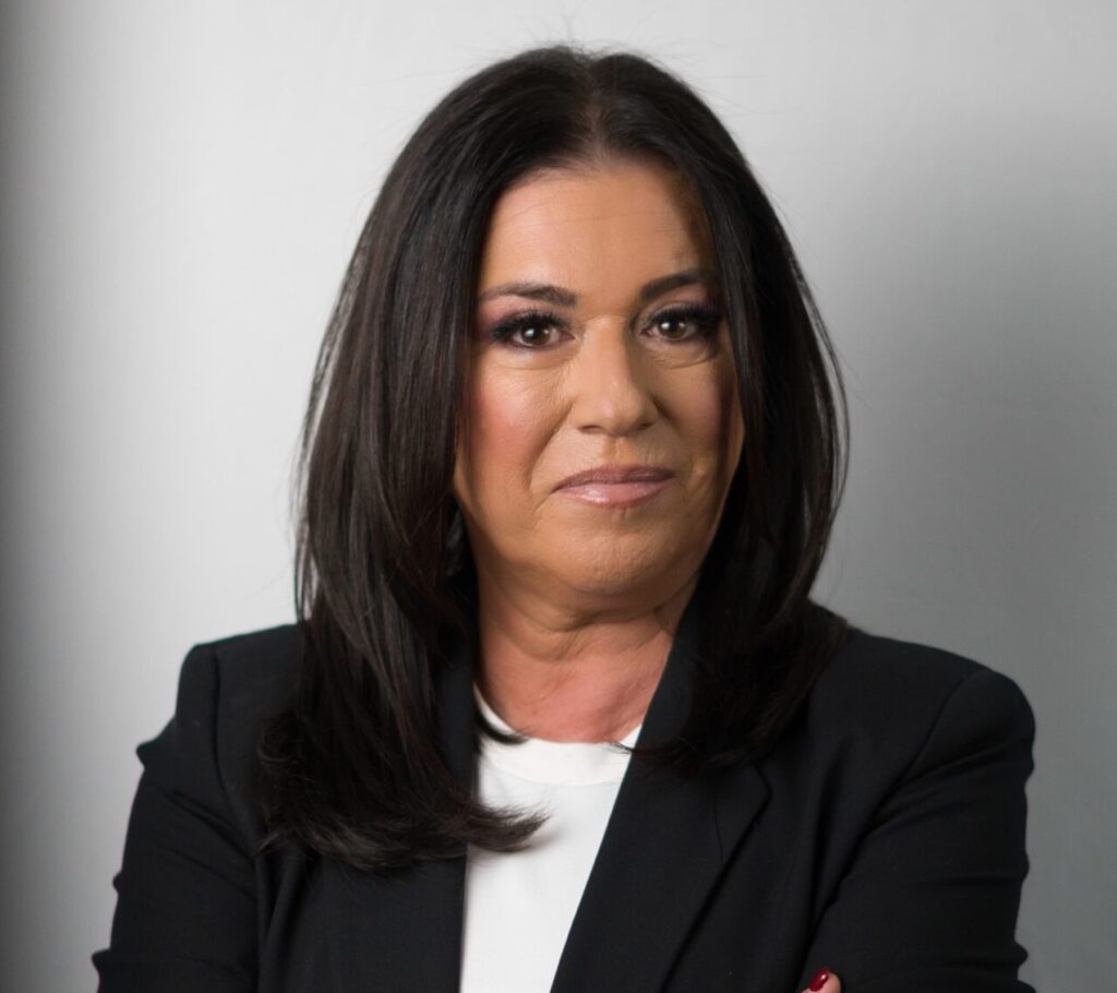 Professional portrait of Fran Malkin in a black blazer, arms crossed, against a light gray background.